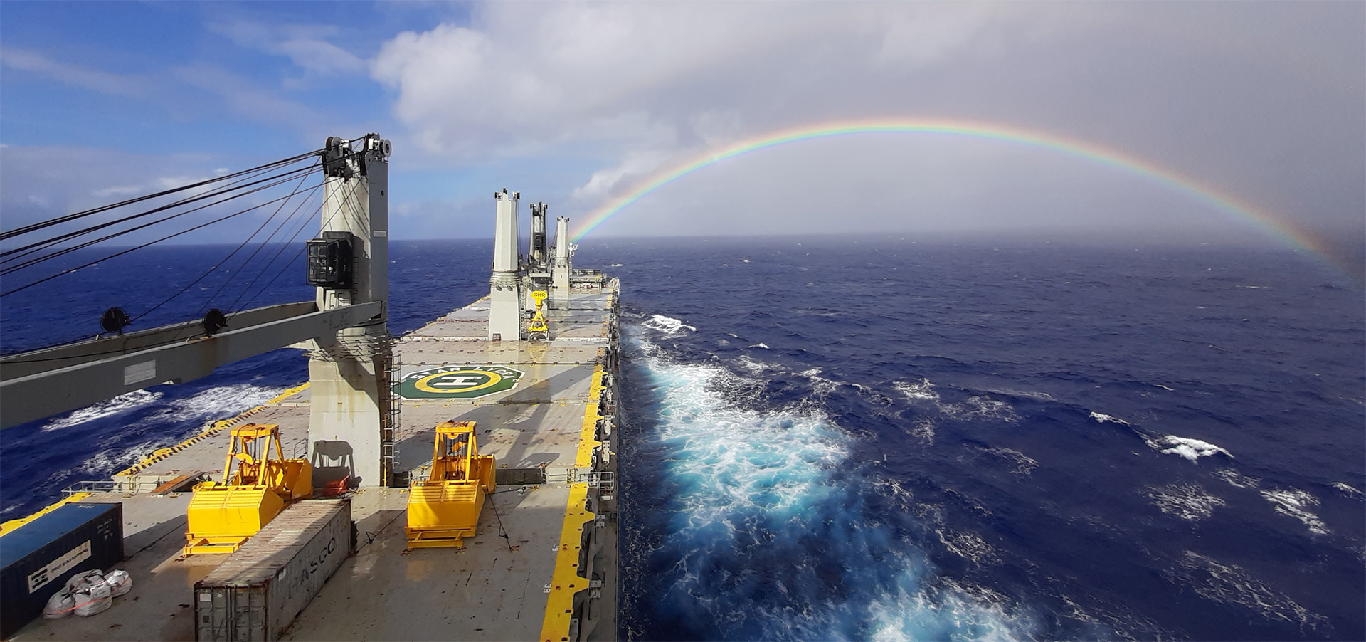 Ship in rough seas and rainbow